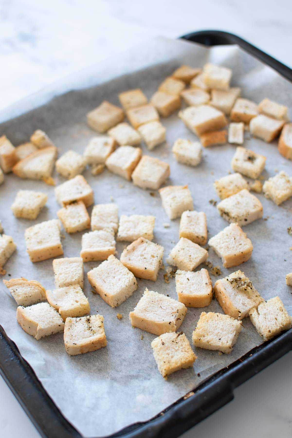 Homemade crispy croutons on a baking sheet.