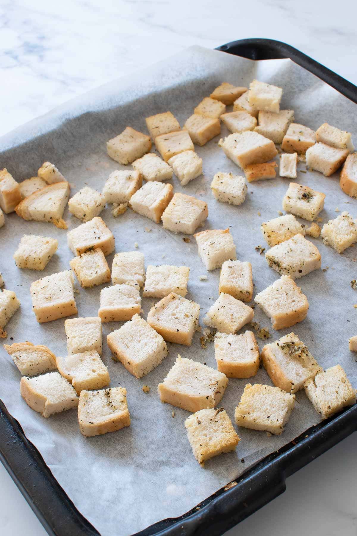 A baking sheet with homemade croutons.