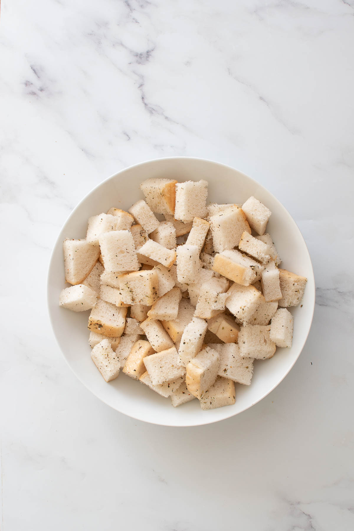 A bowl with seasoned cubes of bread.