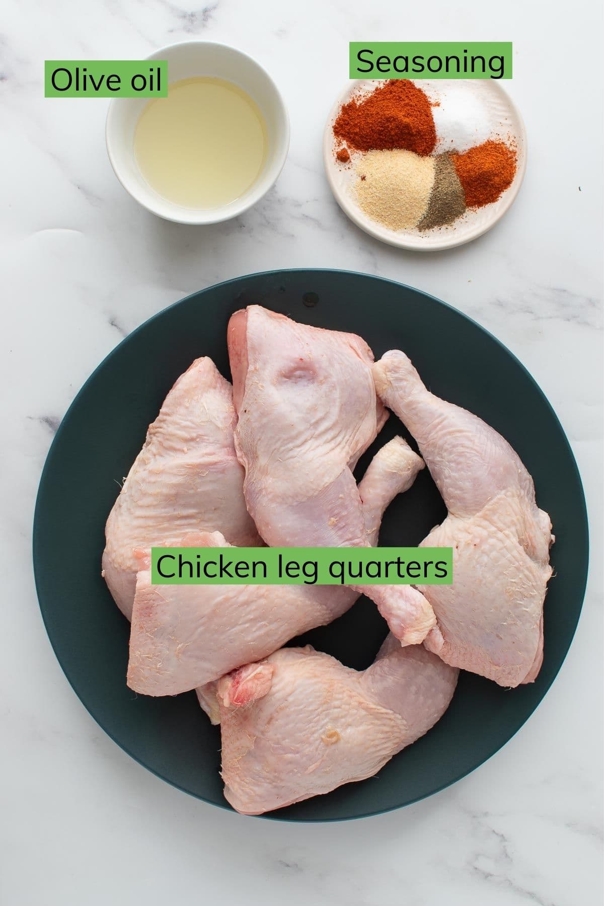 Chicken quarters, seasoning and olive oil on a table.