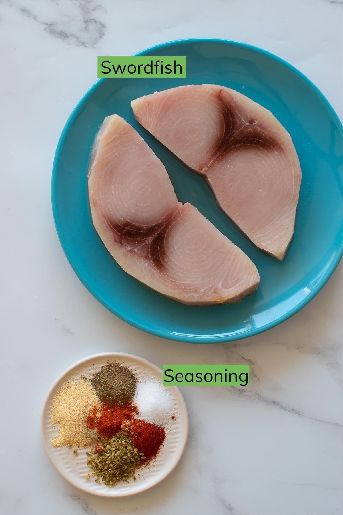 Raw swordfish fillets and seasoning laid out on a table.