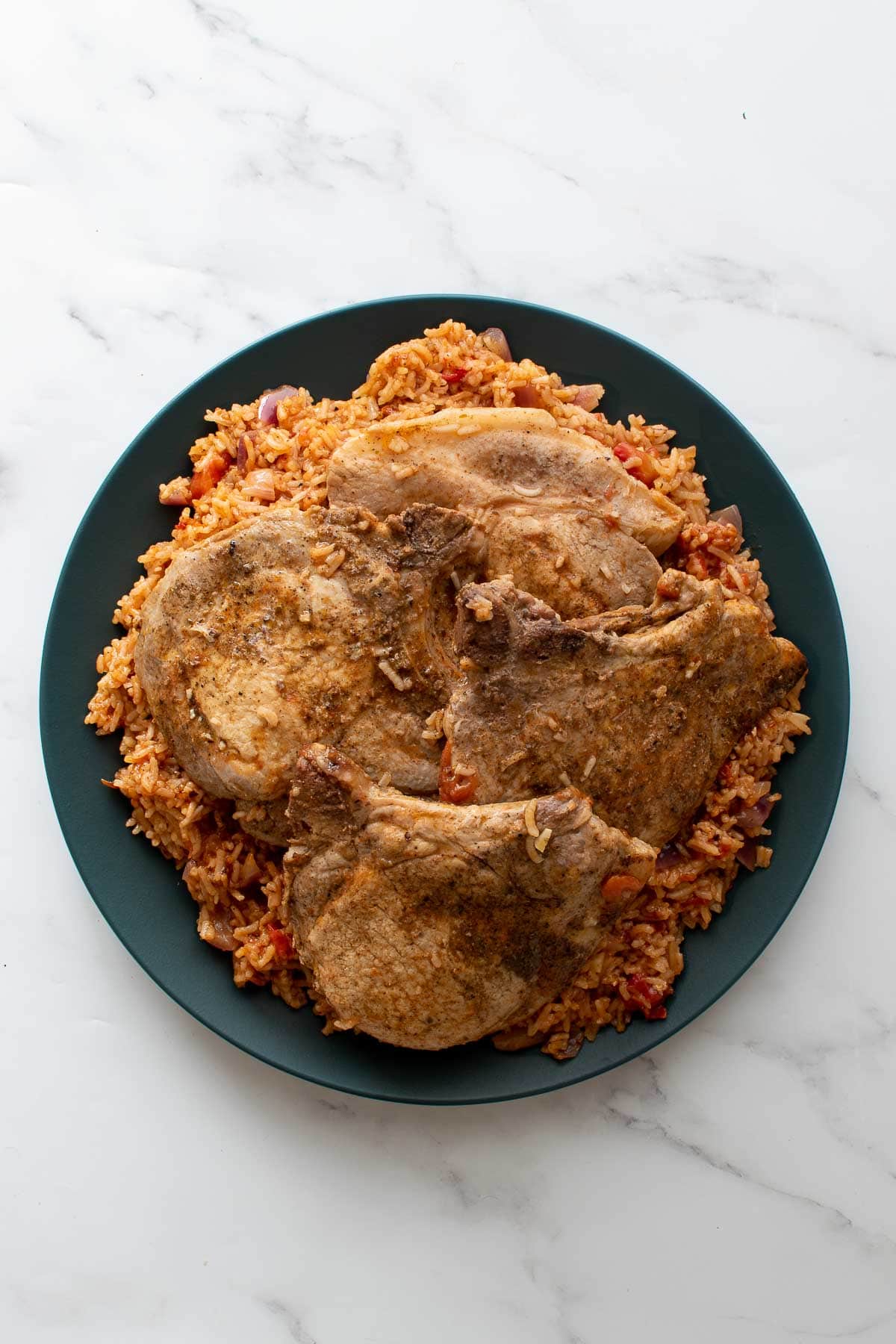 A plate of pork chops and rice.