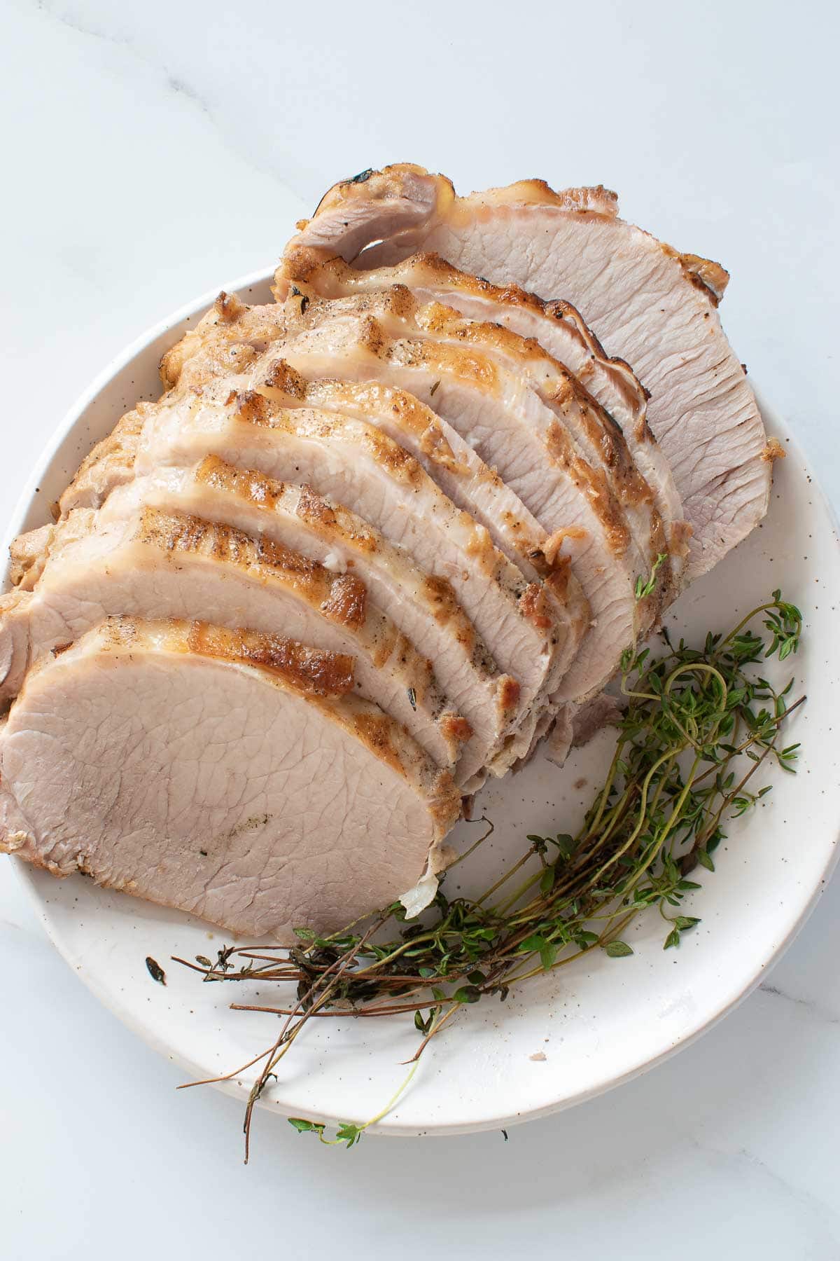 Sliced instant pot pork loin with thyme.