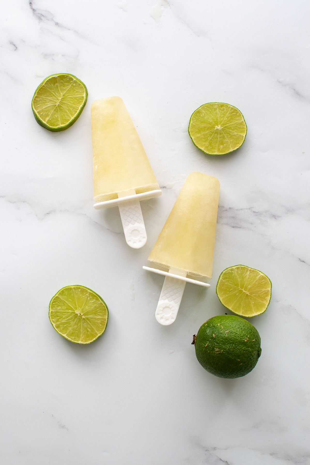 Two frozen lime popsicles.