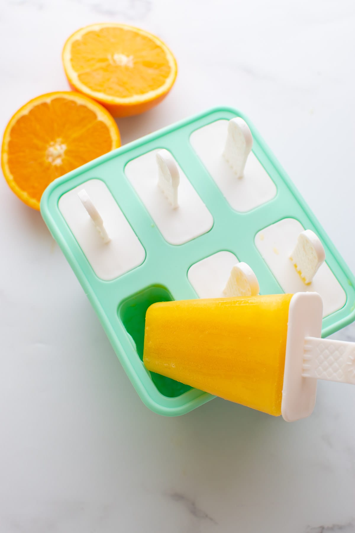 Removing a frozen popsicle from a popsicle mould.