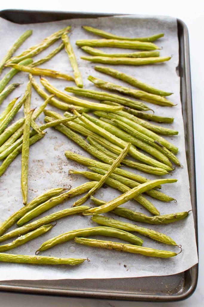 Roasted green beans on a baking sheet.