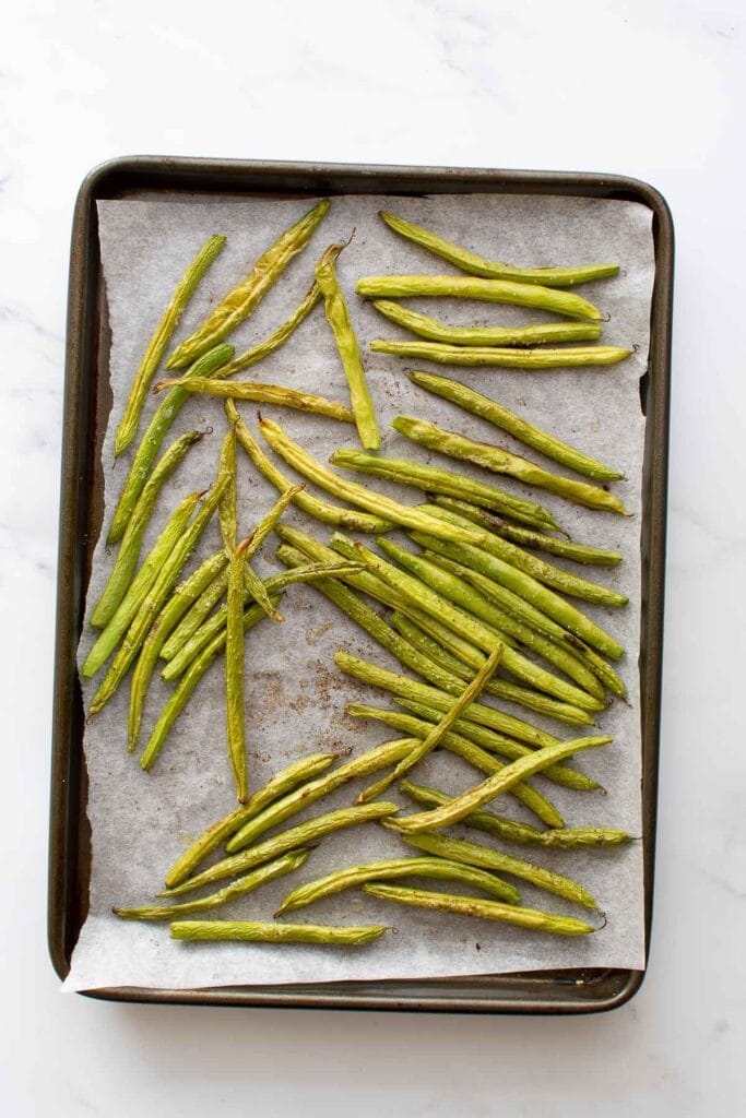 Oven roasted green beans on a baking sheet.