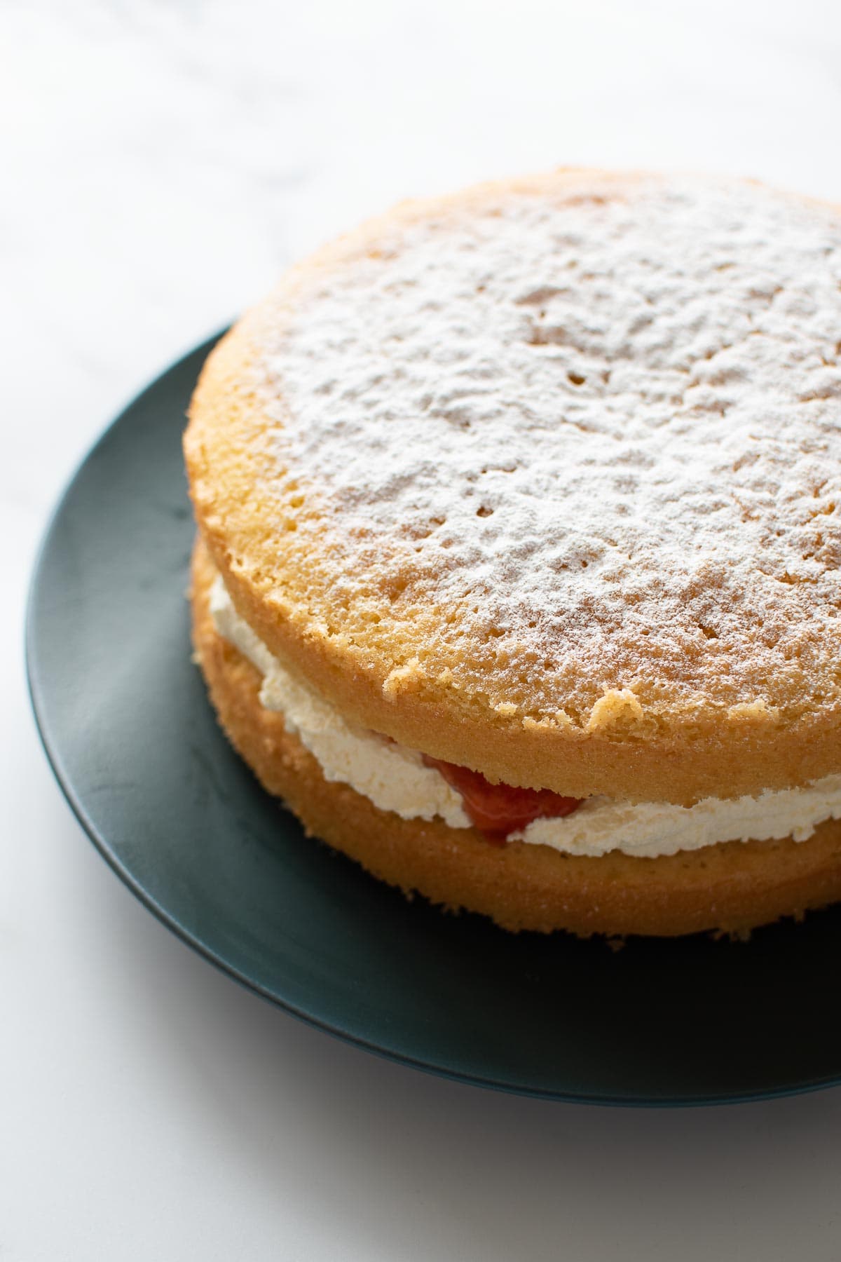 Vanilla sponge cake with jam and whipped cream.