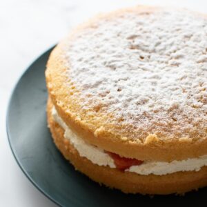 Vanilla sponge cake with whipped cream and strawberry jam.