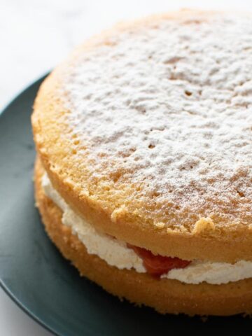 Vanilla sponge cake with whipped cream and strawberry jam.