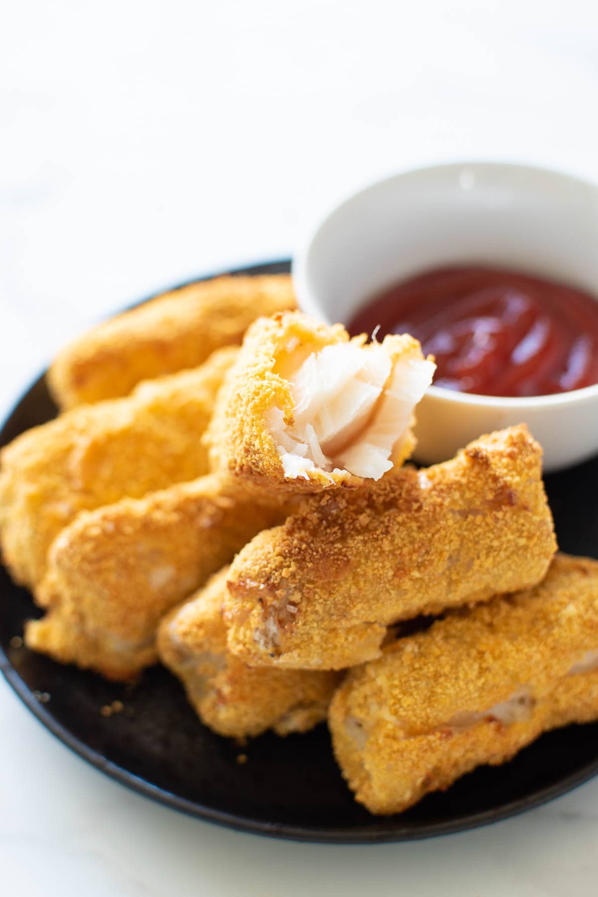 Air fried fish sticks on a plate.