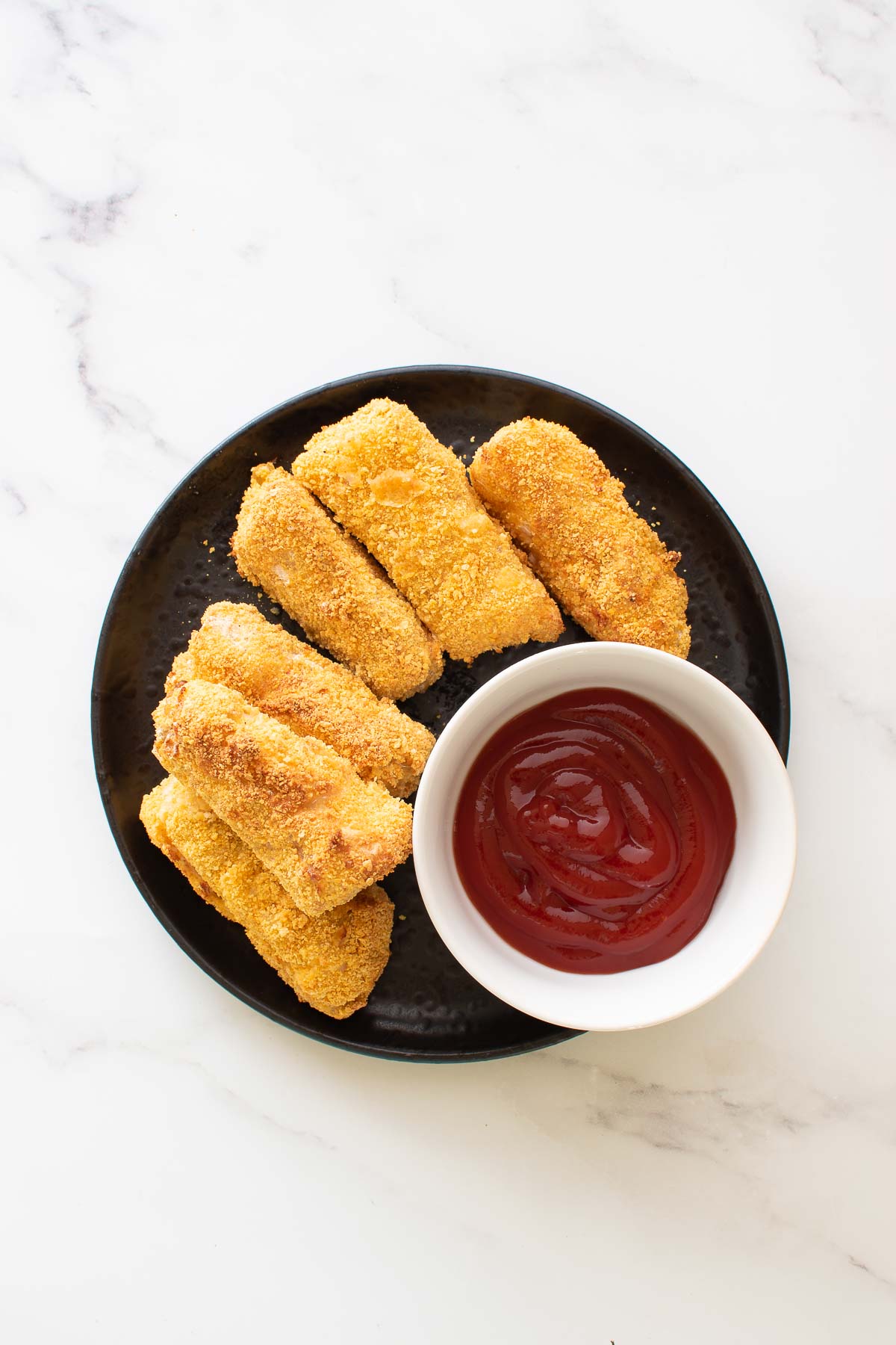 A plate of golden homemade fish sticks.