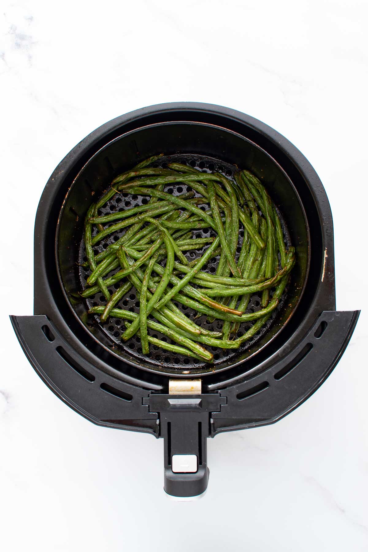 Roasted green beans in an air fryer.