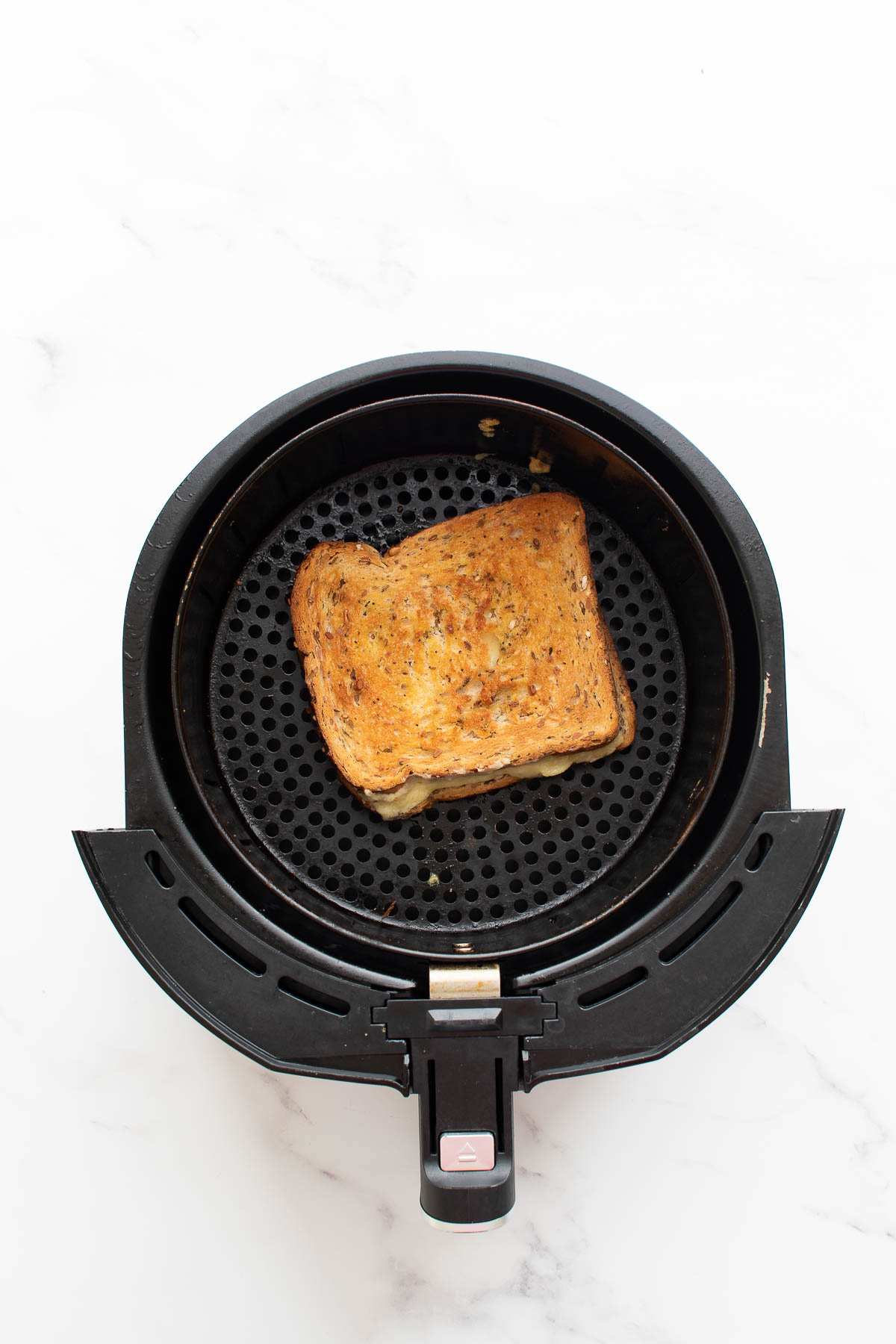 Air fryer with grilled cheese sandwich.