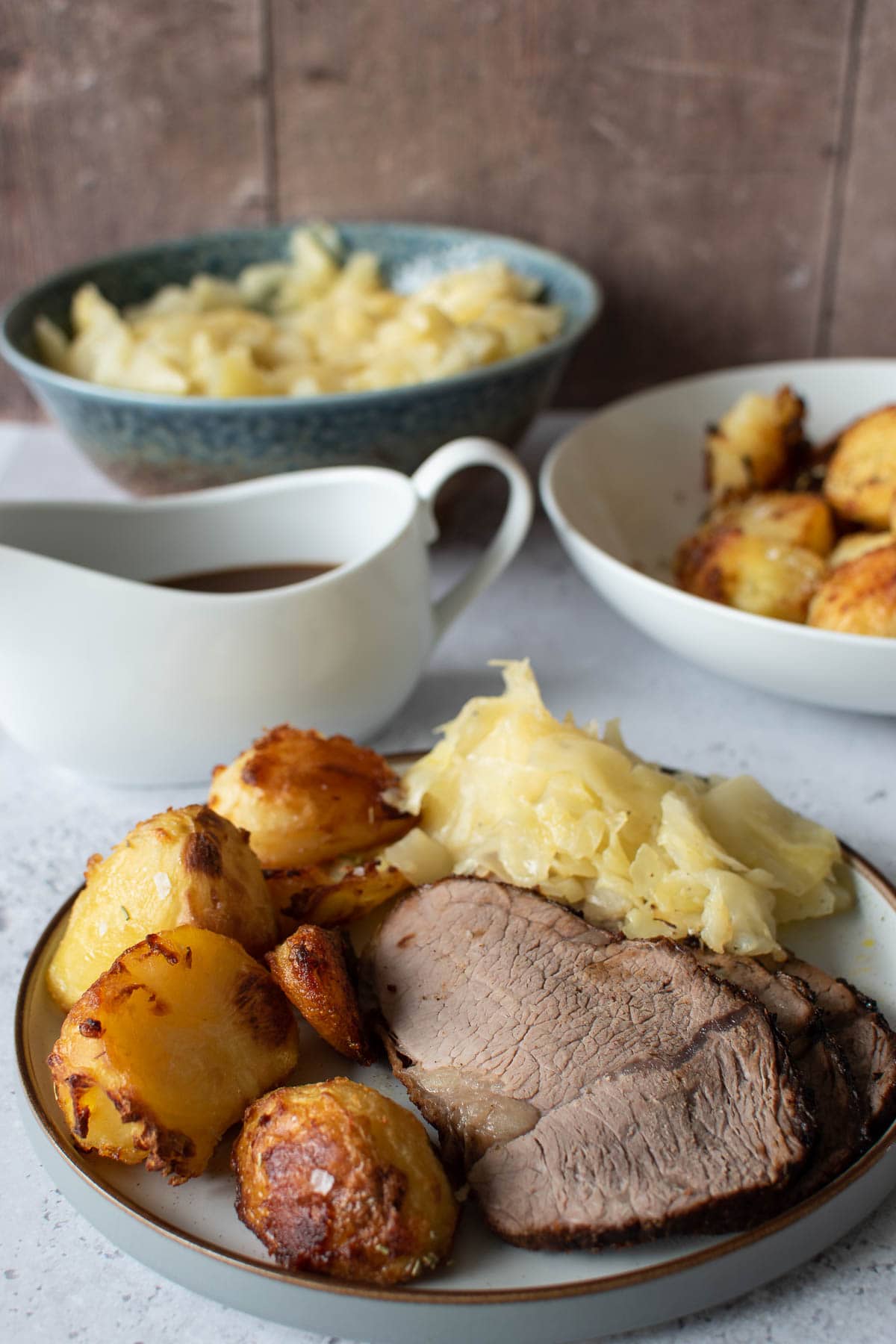 Roast dinner with air fryer roast beef, instant pot cabbage, crispy roasted potatoes and gravy.