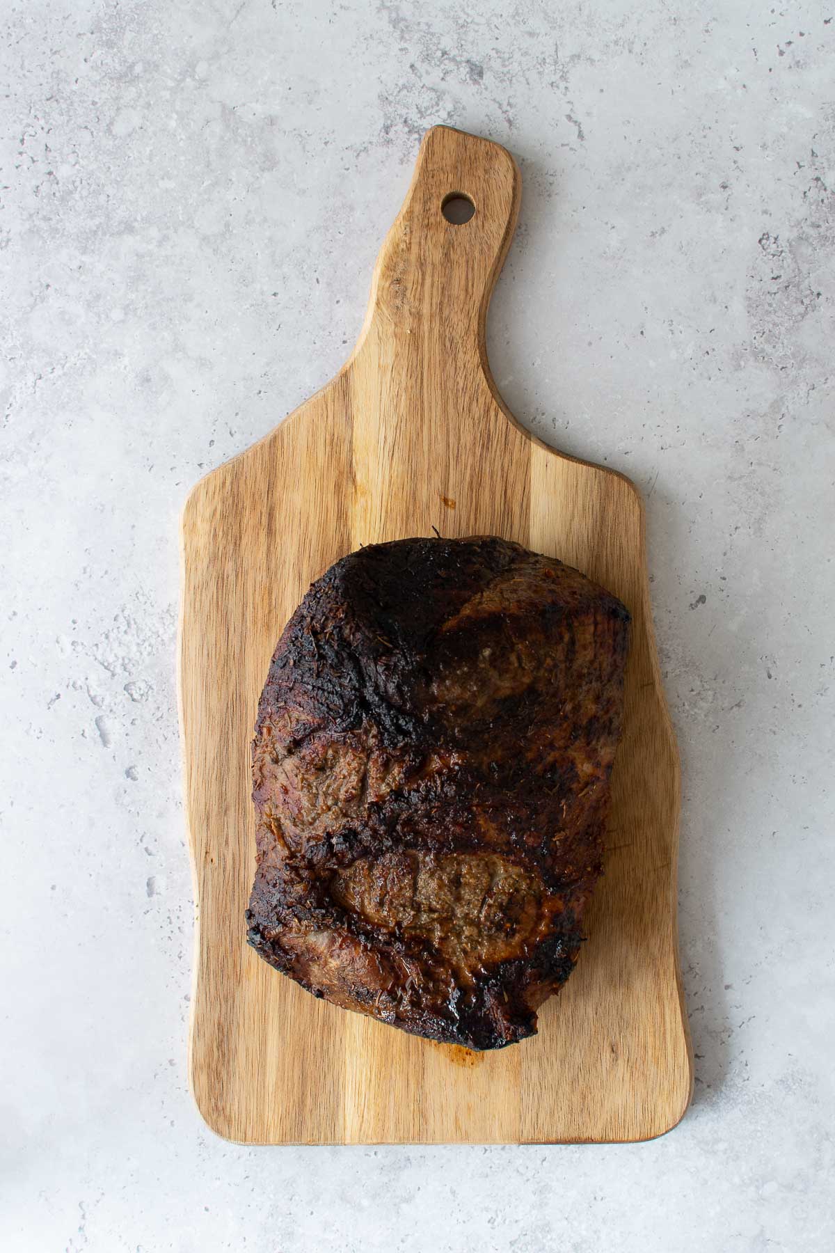 Air fried beef roast on a cutting board.