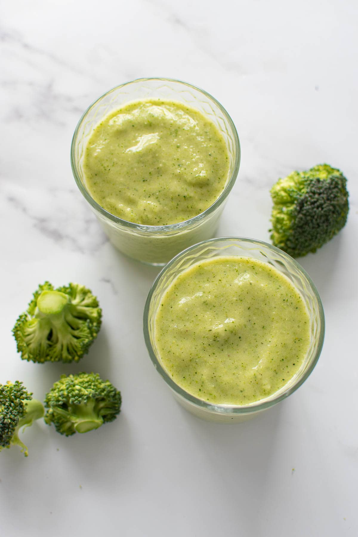 Glasses with pineapple and broccoli smoothie.