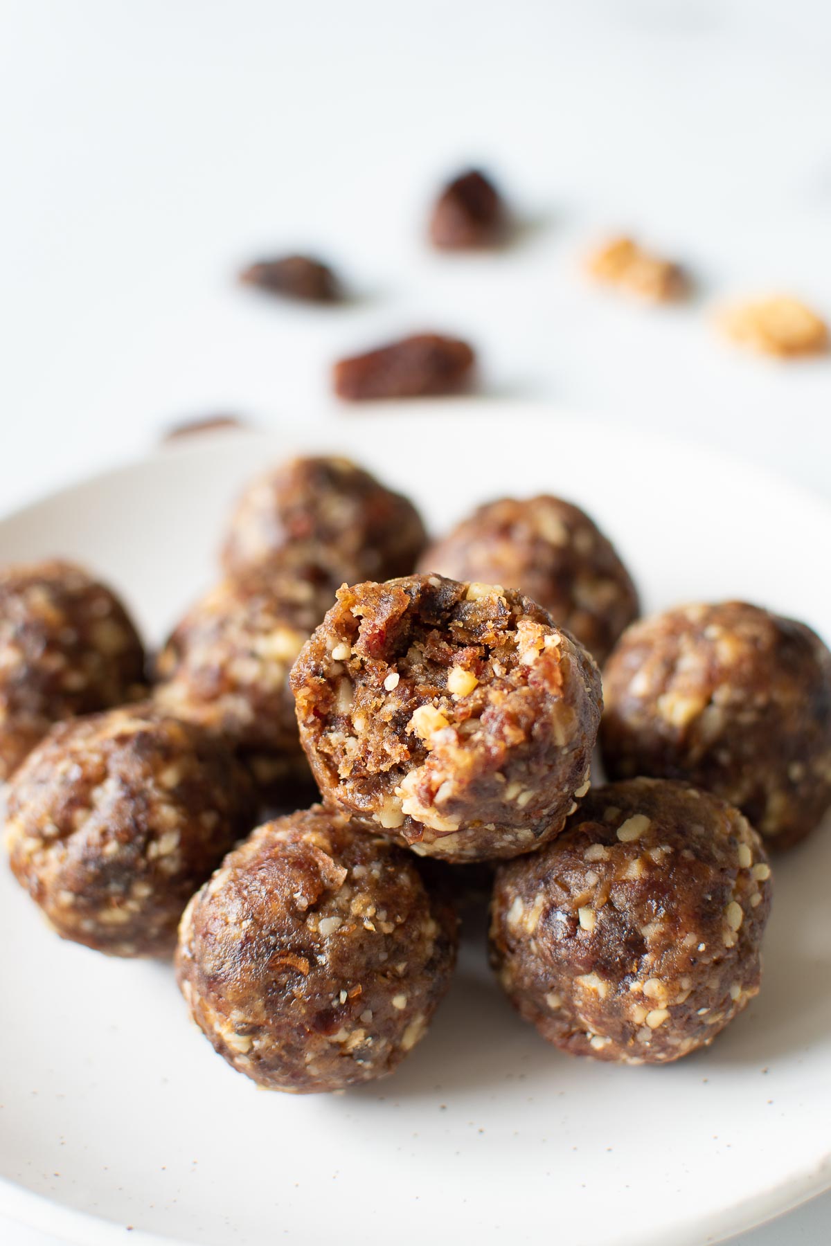 Energy balls with dates and walnut, one has had a bite taken out of it.