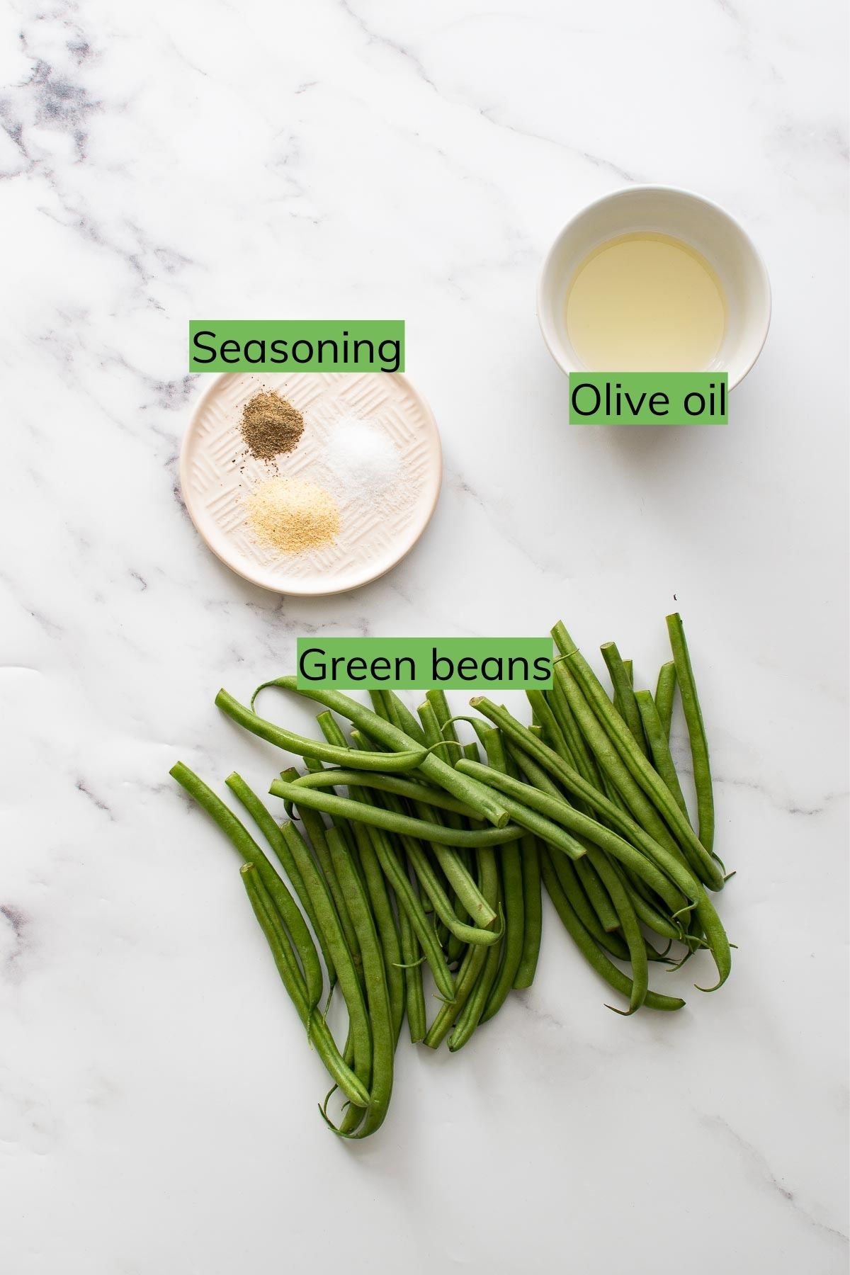 Green beans, seasoning and olive oil on a table.