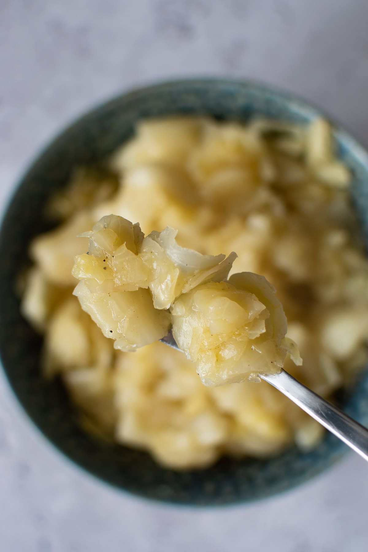 A fork lifting pressure cooked cabbage up from a bowl.