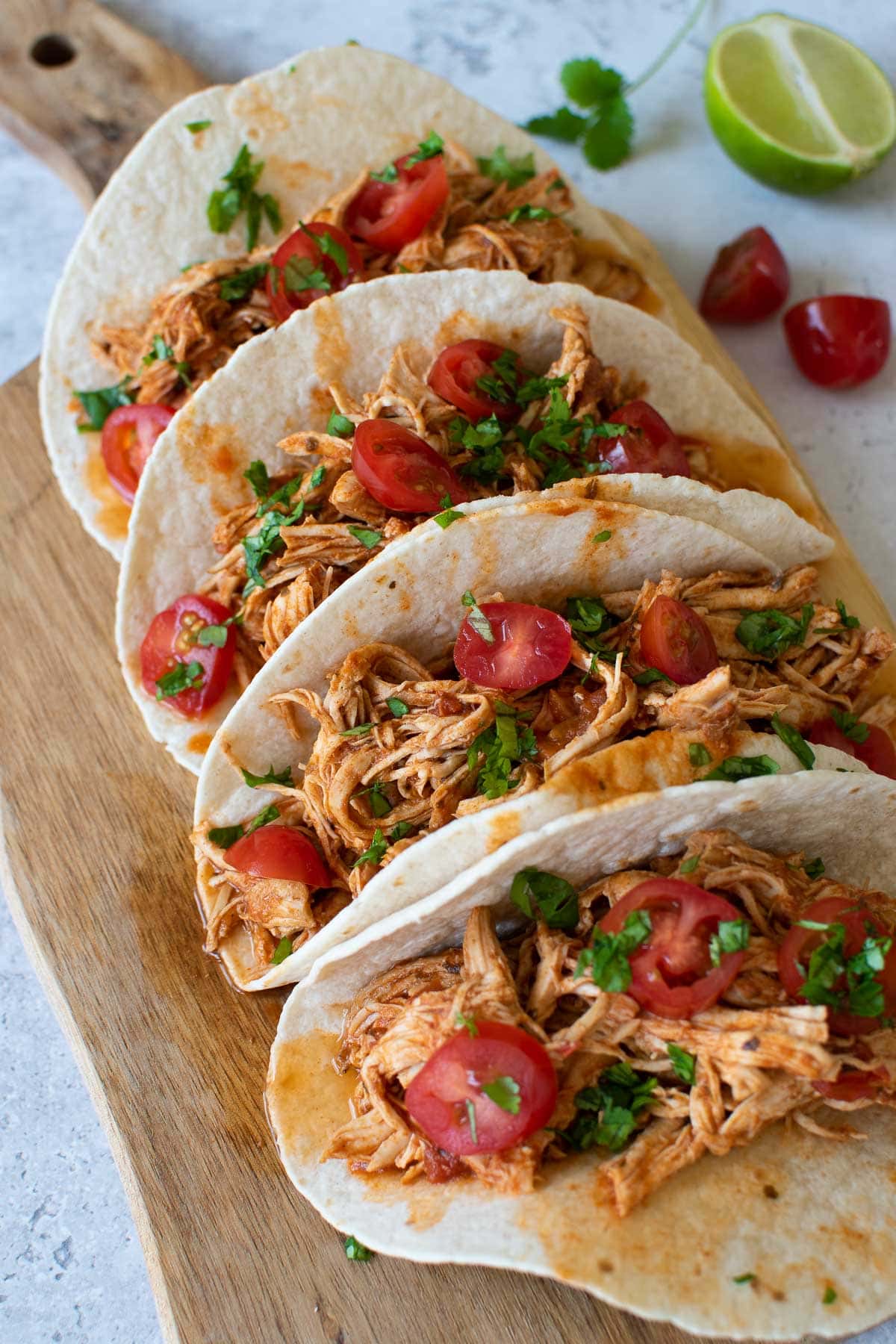 Shredded chicken tacos with tomatoes and cilantro.