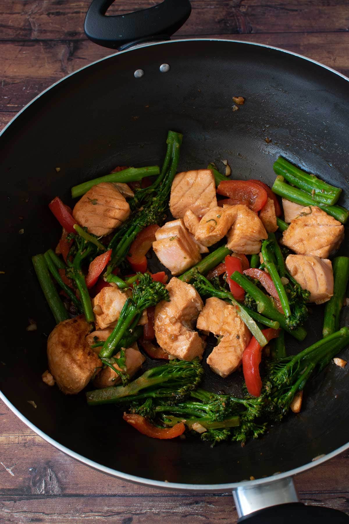 Salmon stir fry in a wok.