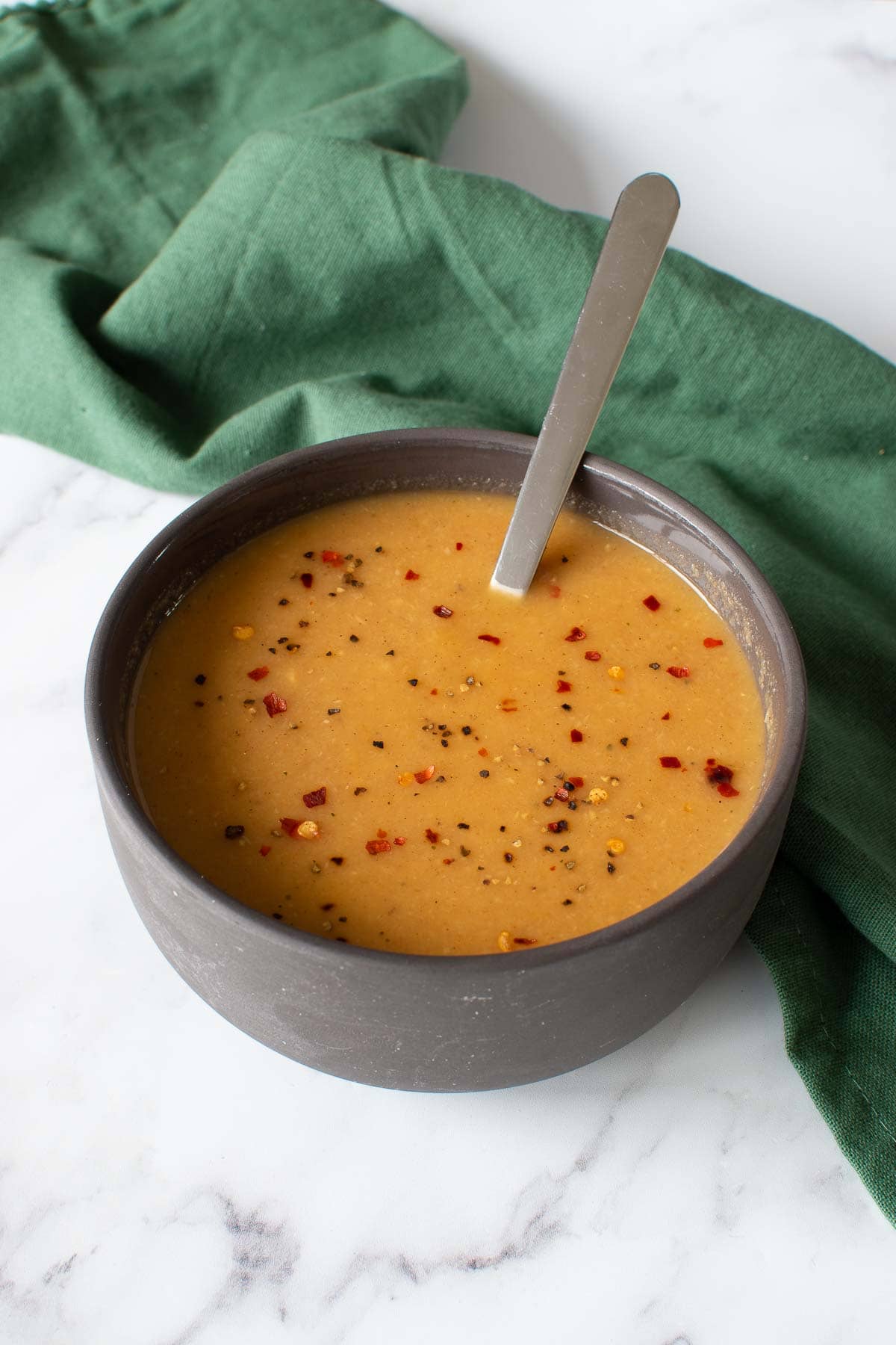 Parsnip soup with a spoon inserted into it.