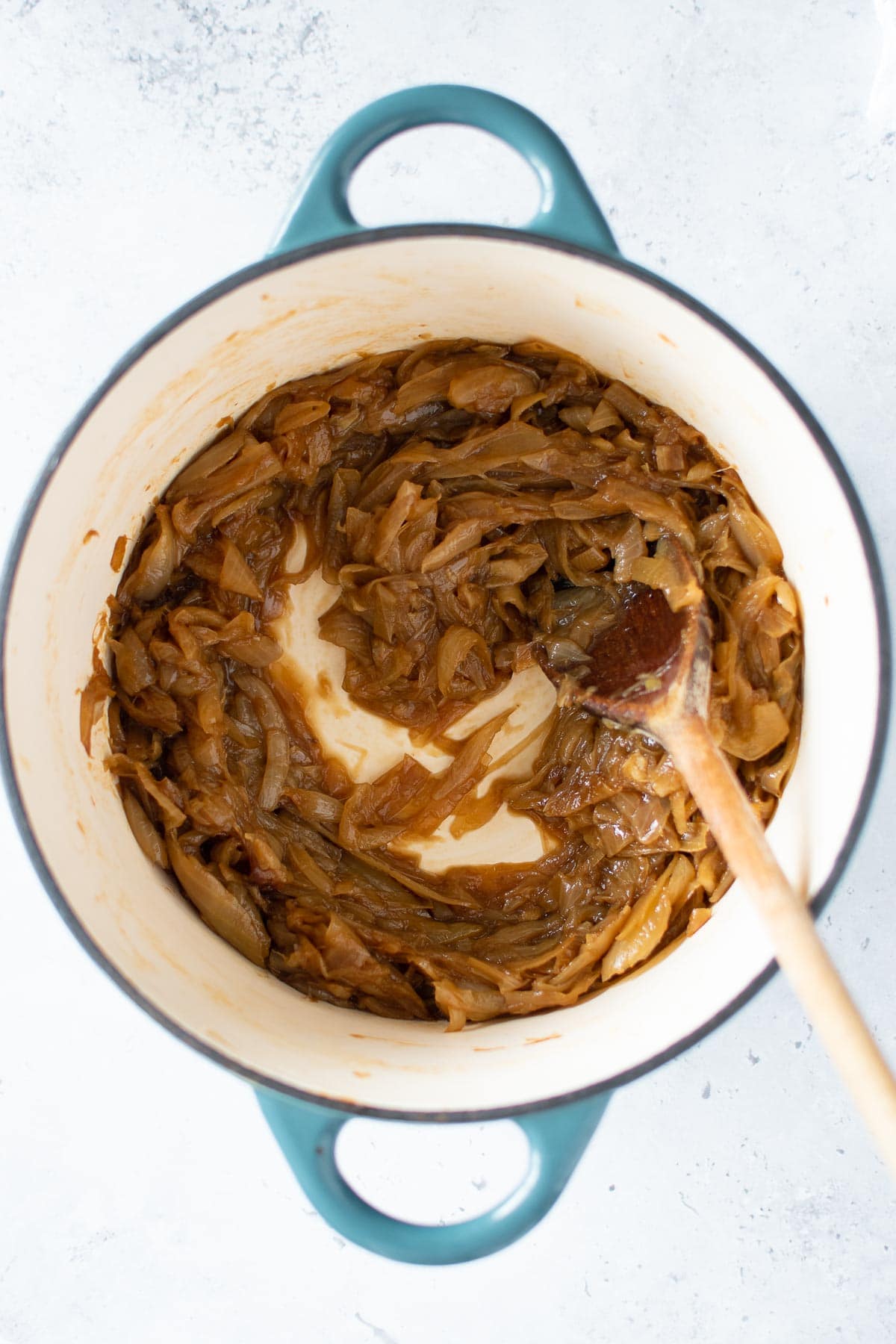 Stirring caramelized onions with balsamic vinegar in a pot.