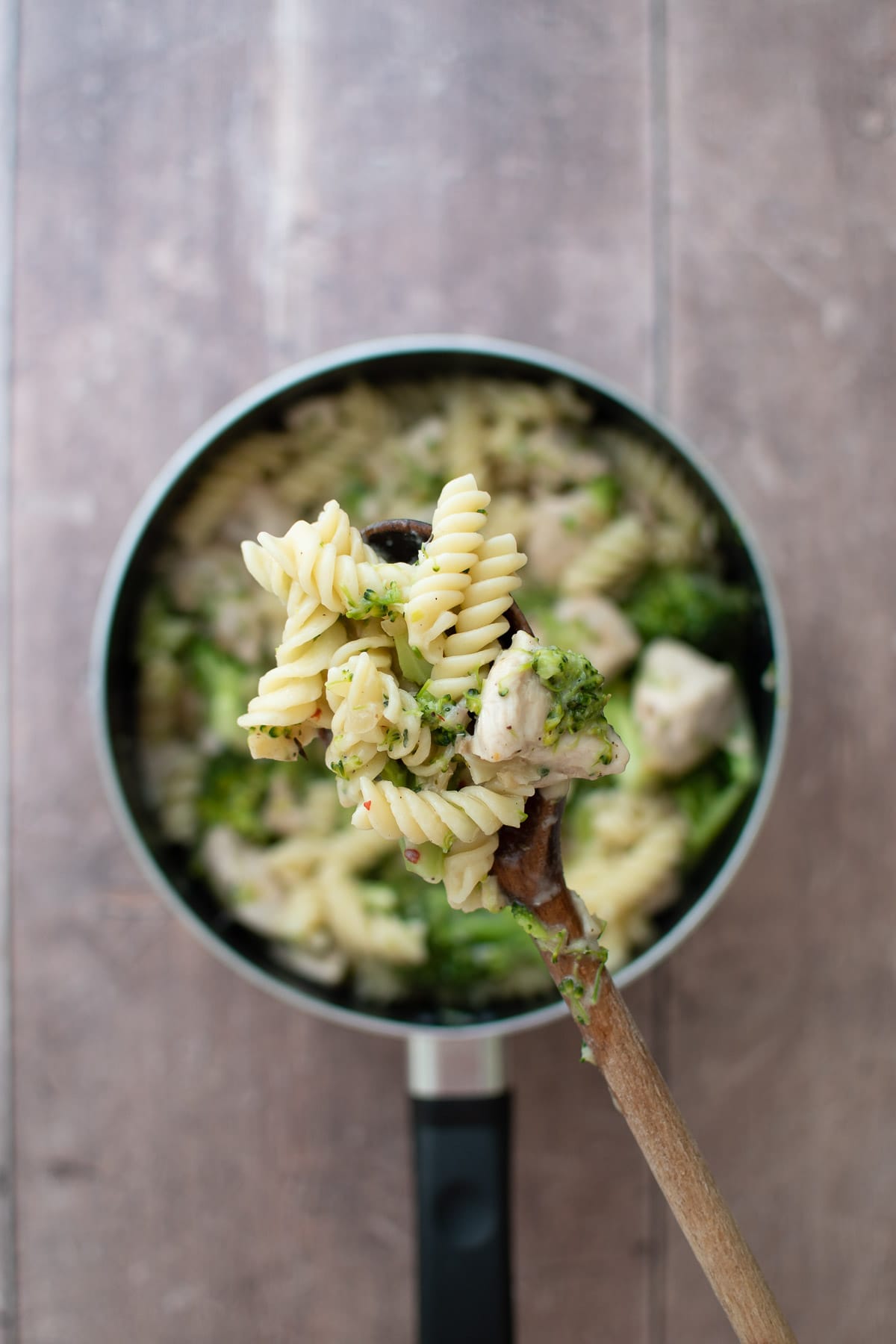 A spoon lifting up a serving of pasta.