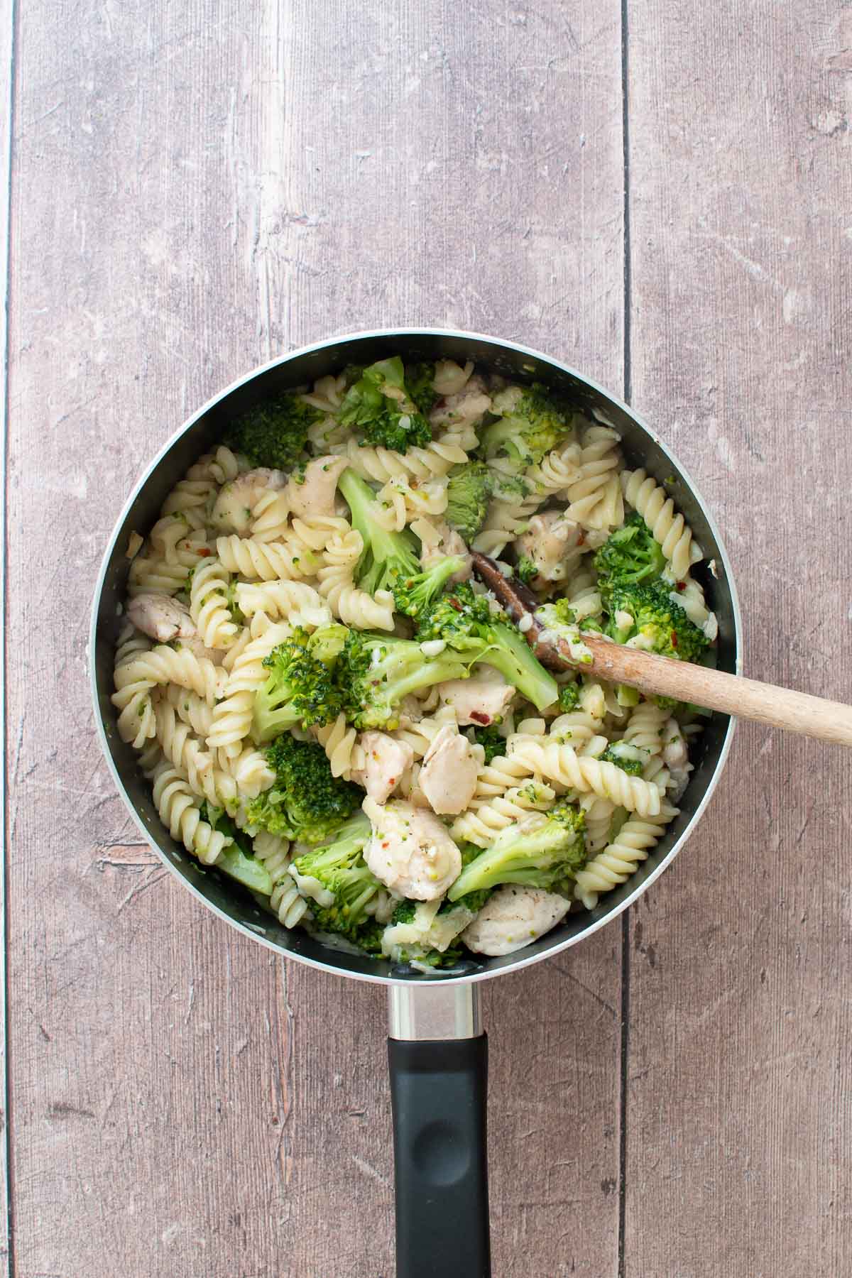 A pan of pasta with broccoli and chicken.