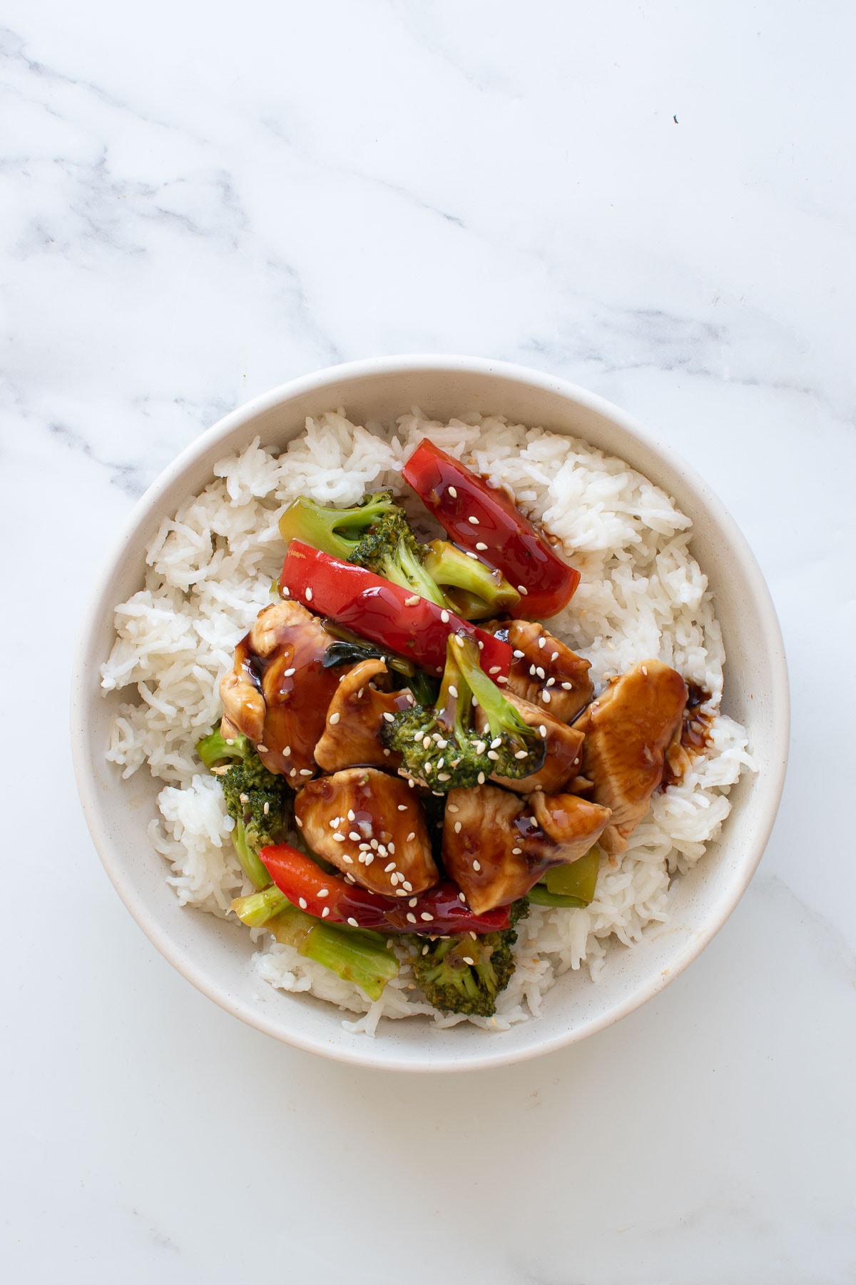 Chicken, broccoli and pepper stir fry with teriyaki sauce on top of rice.