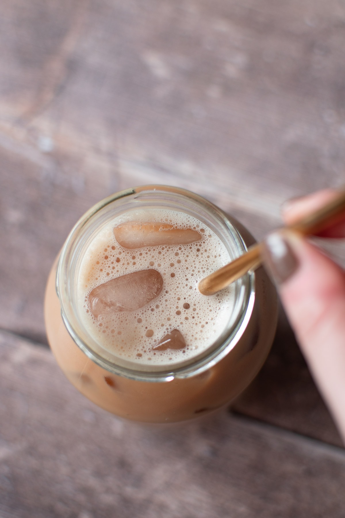 Stirring a glass of iced latte.