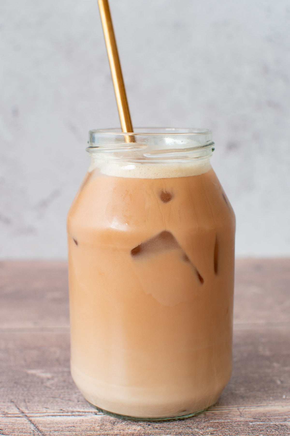 A glass of healthy iced chai latte with ice cubes.