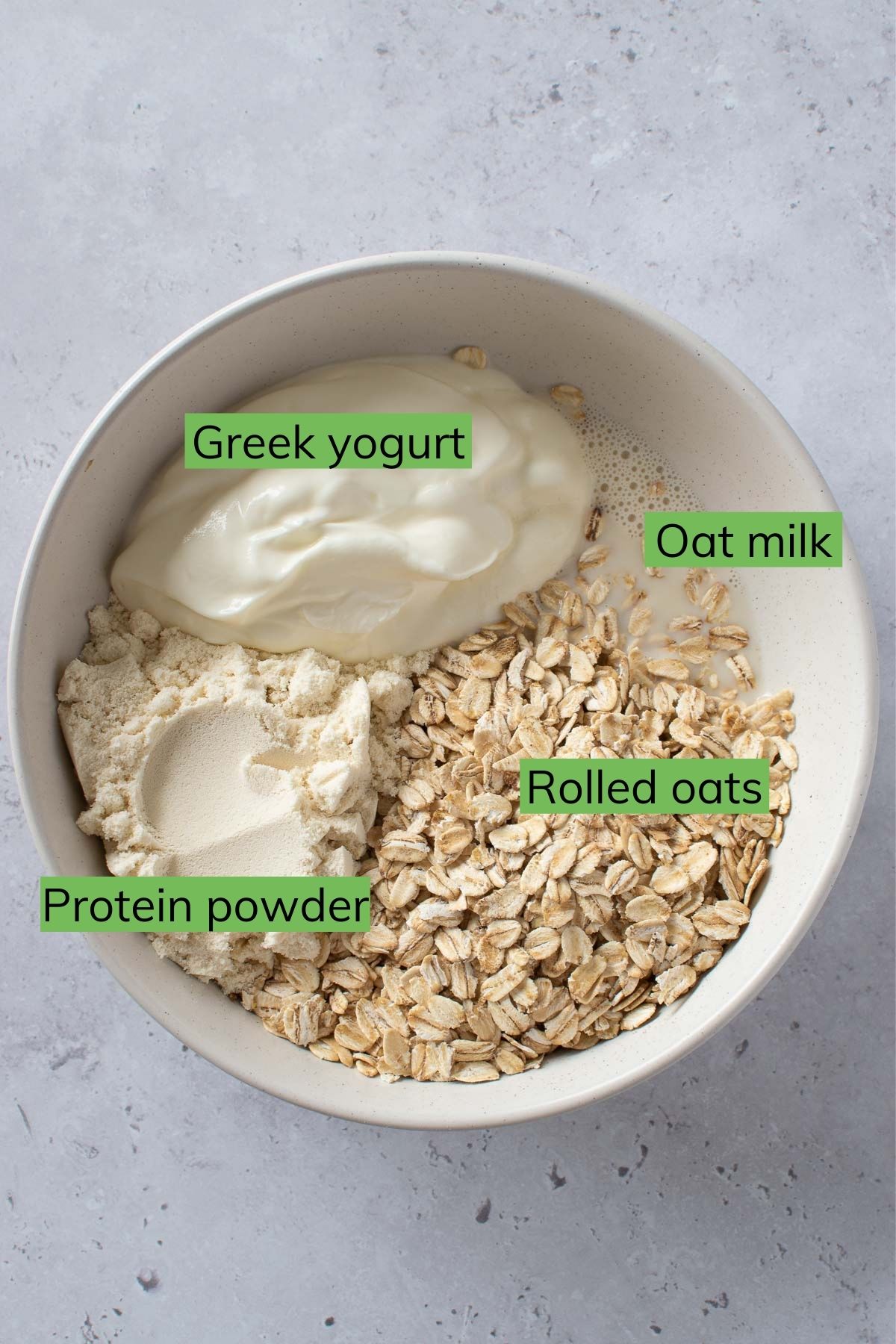 A bowl with the ingredients for protein overnight oats.