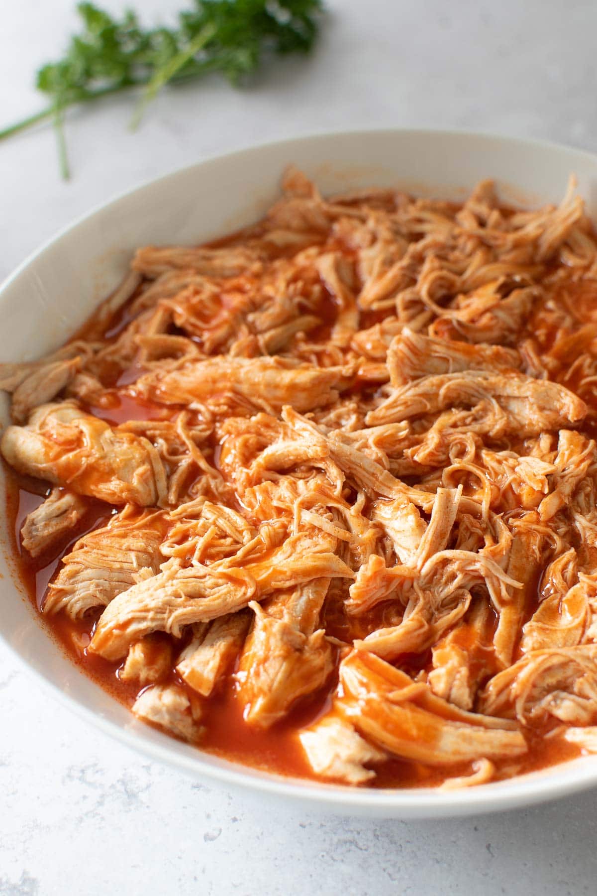 Close up of pulled chicken with buffalo sauce.