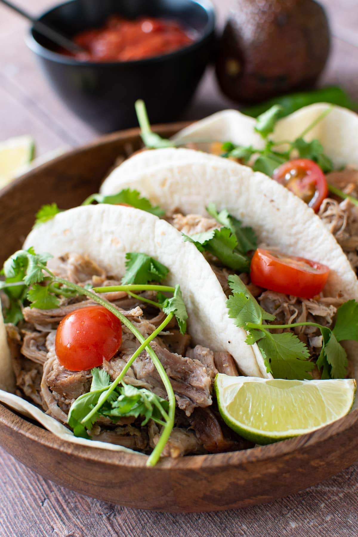 Instant pot pulled pork tacos with tomatoes, lime and cilantro.