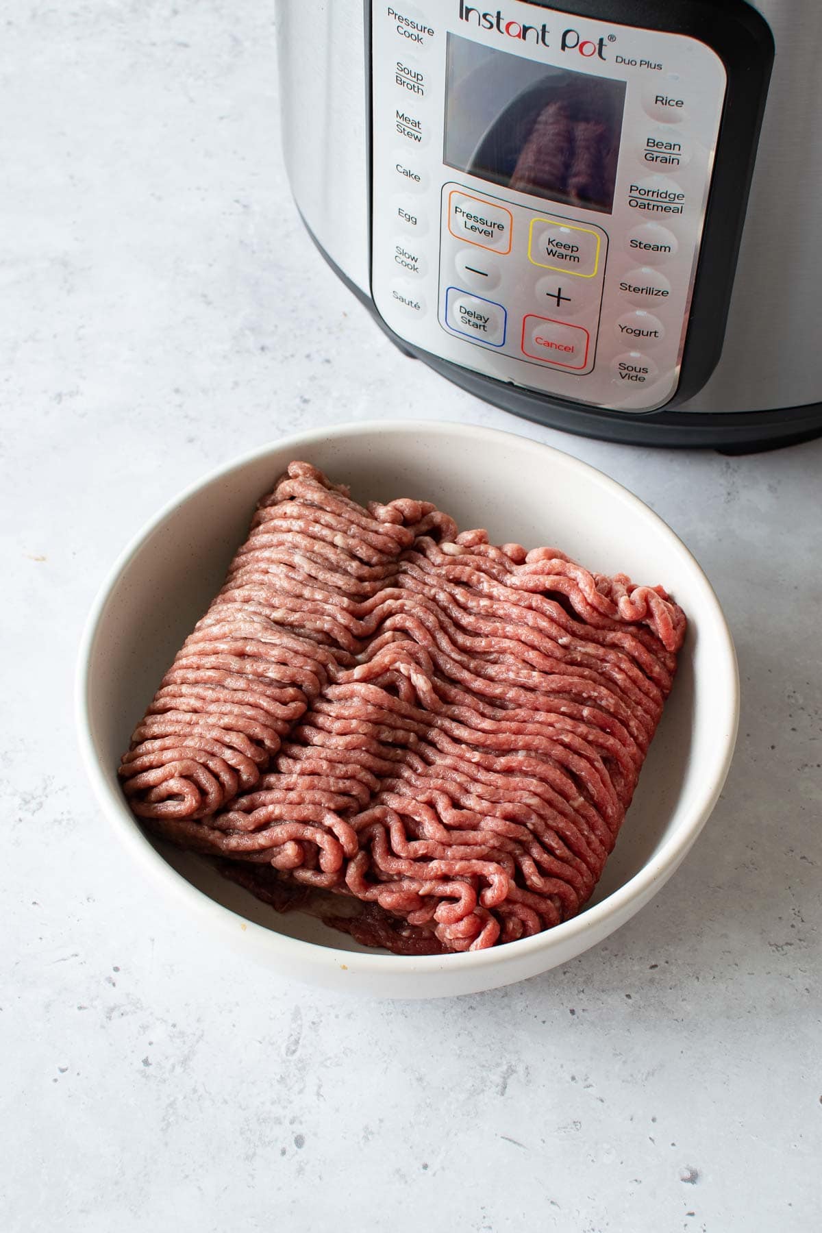 Ground beef in front of an Instant Pot.