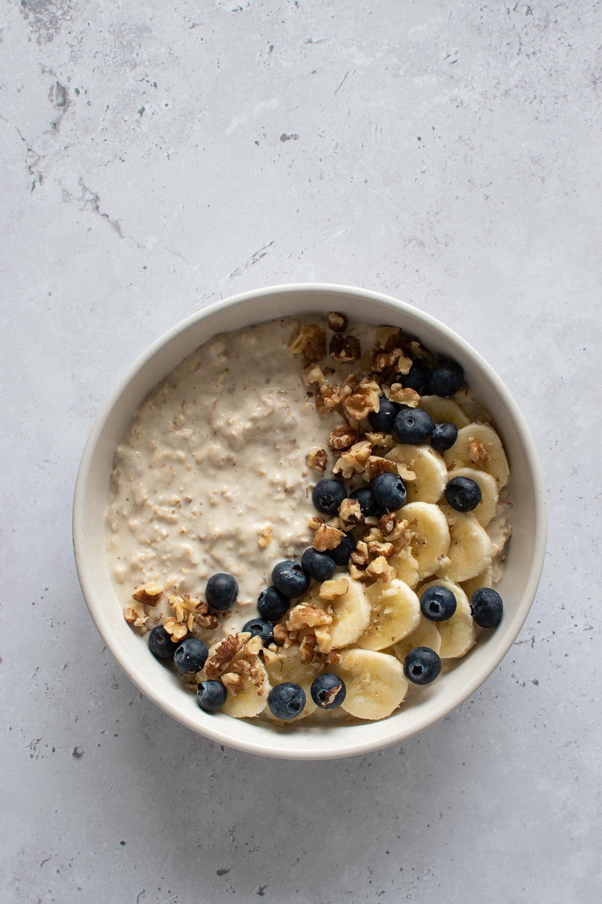 A bowl of protein overnight oats garnished with fruit.