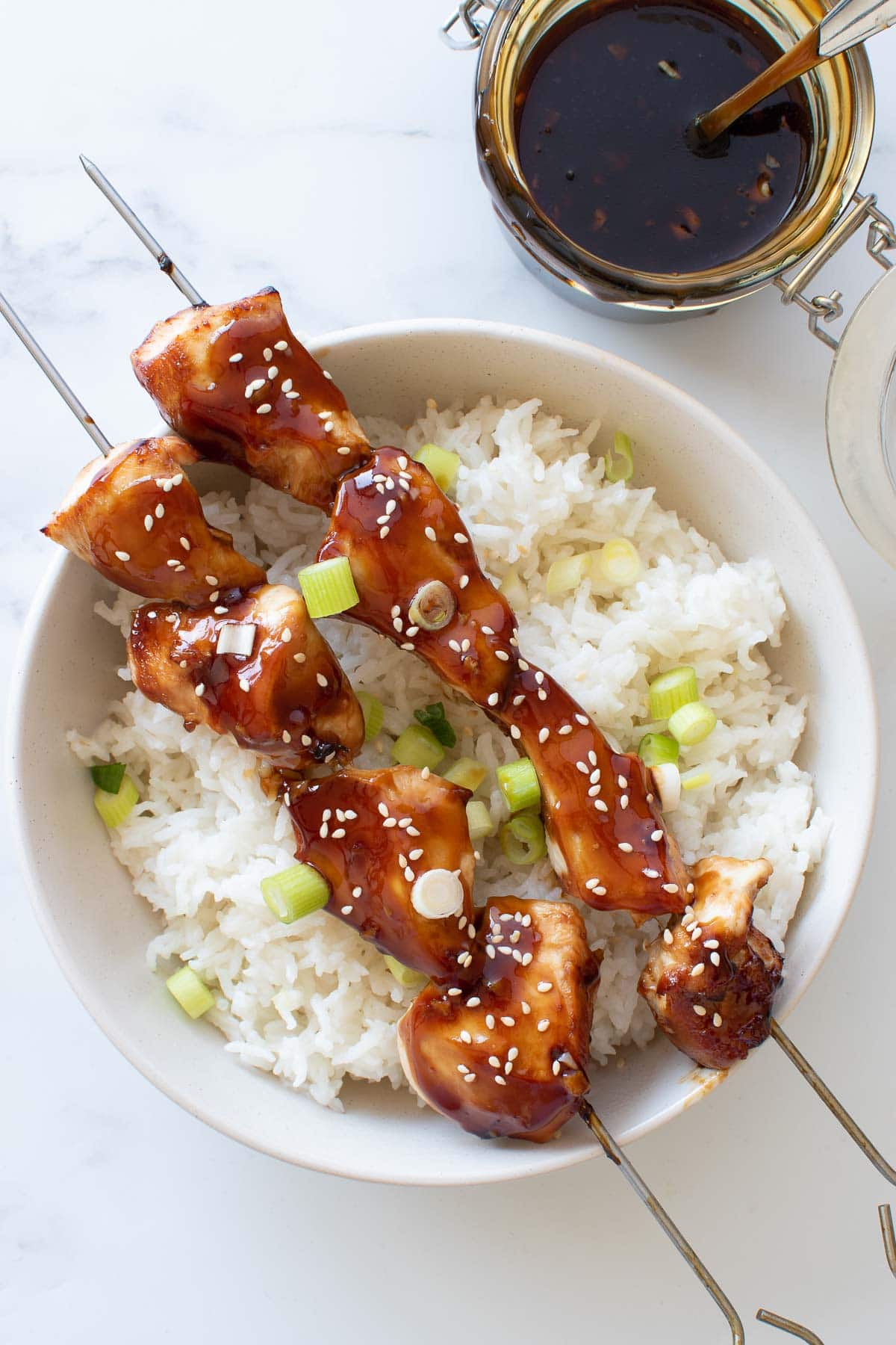 Chicken spears with rice and teriyaki sauce.