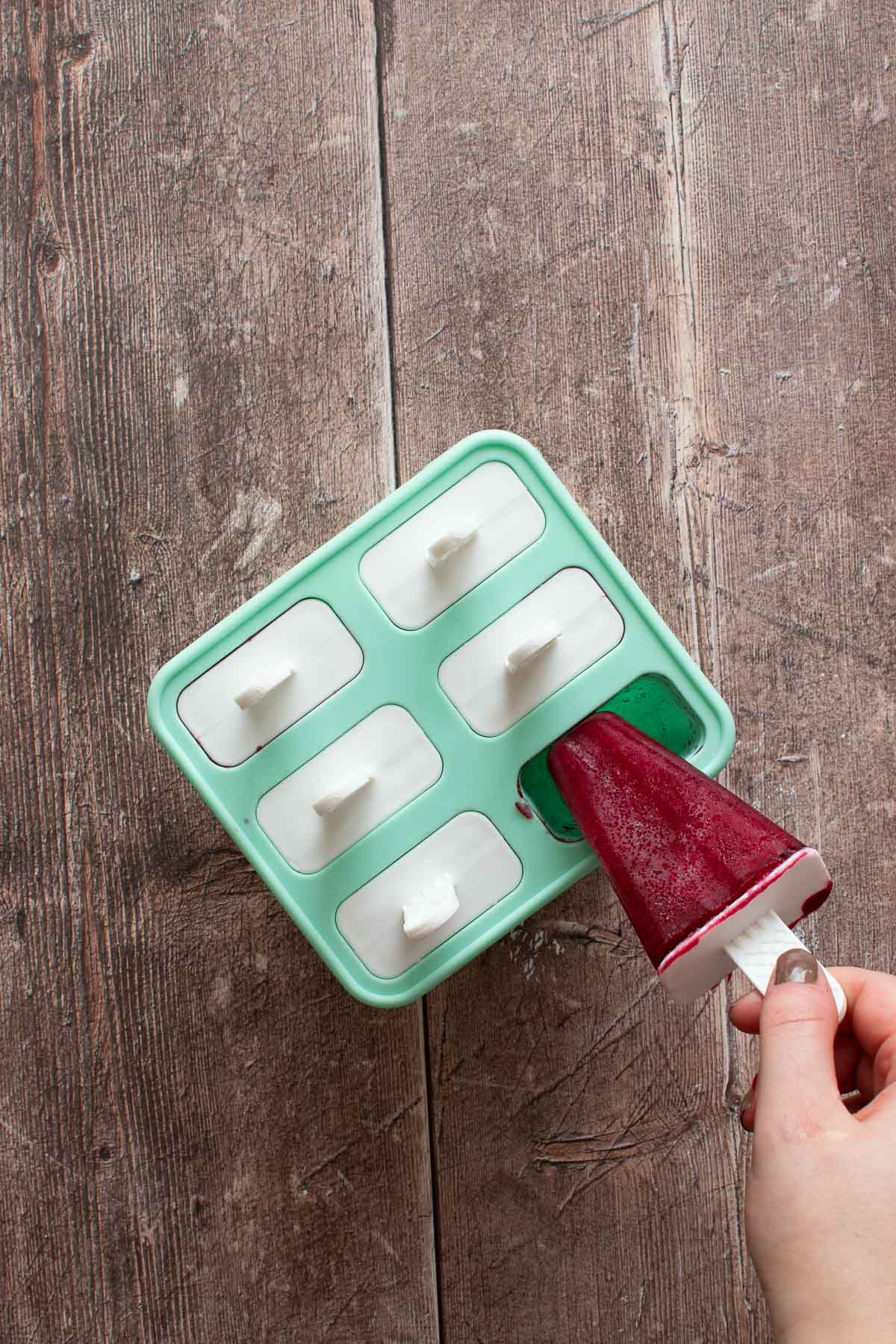 Pulling a popsicle out of molds.