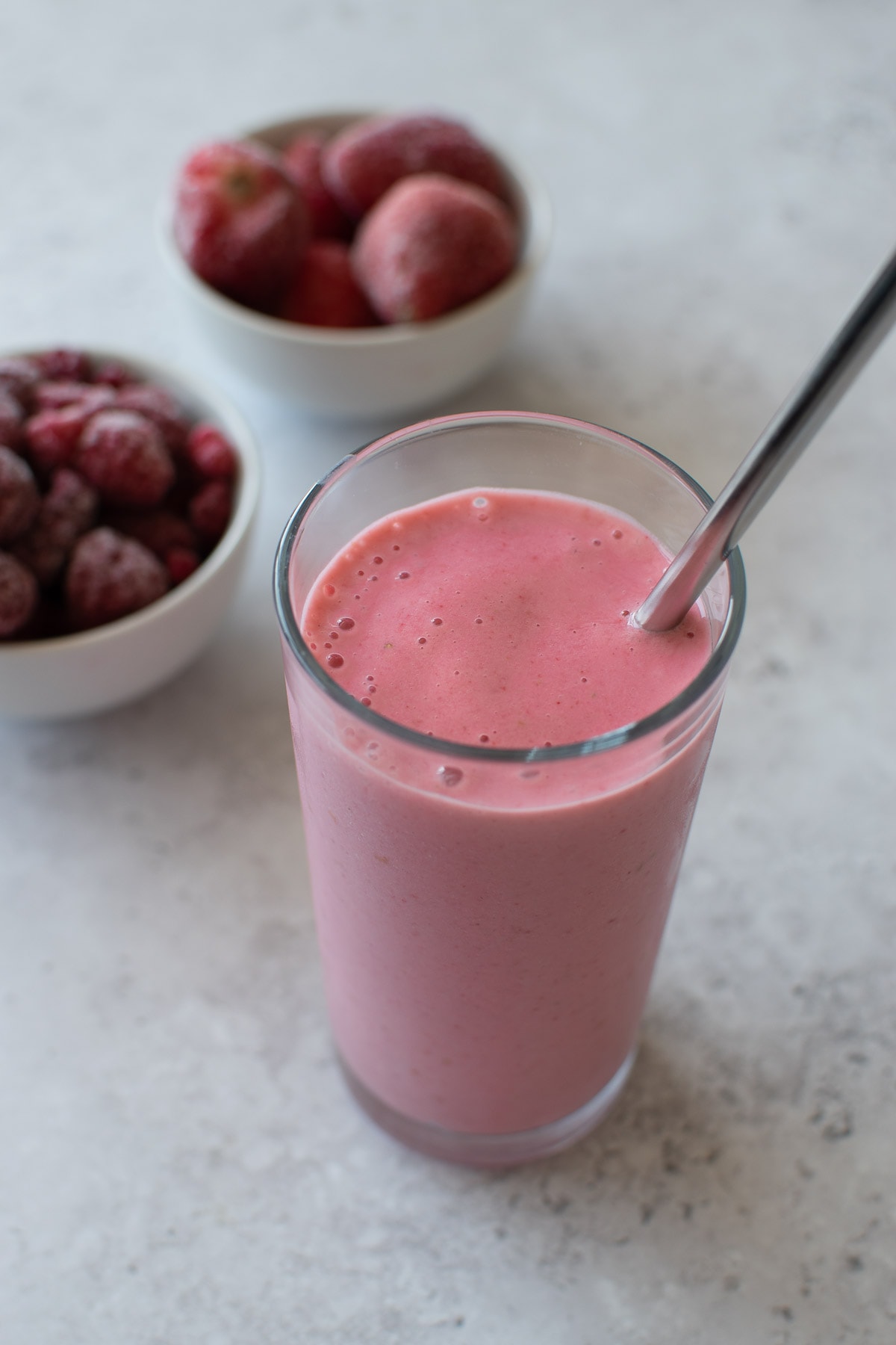 A glass of creamy kefir smoothie with strawberries and raspberries.