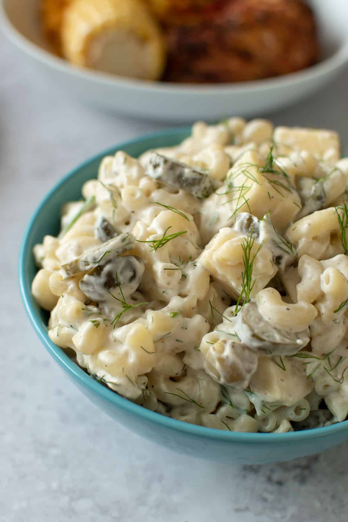 Close up of pasta salad with dill and pickles.