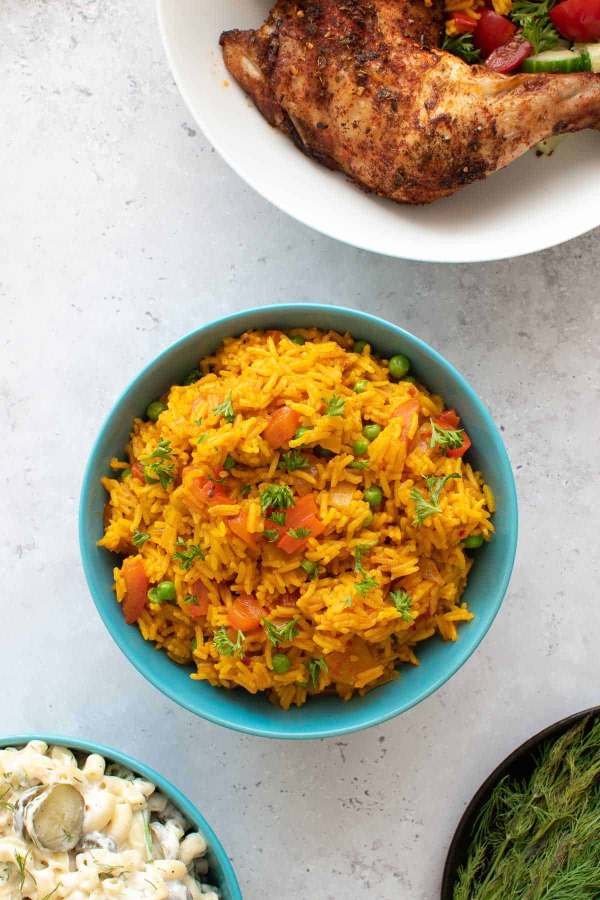 A bowl of spicy rice with chicken on the side.