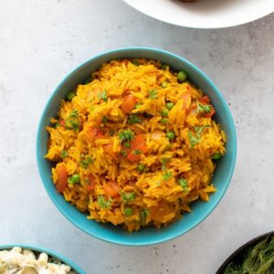 A bowl of homemade nandos spicy rice with peas and peppers.