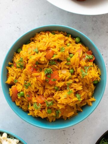 A bowl of homemade nandos spicy rice with peas and peppers.