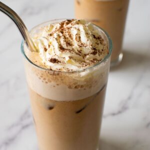 Close up of iced latte with whipped cream.