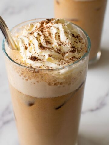 Close up of iced latte with whipped cream.