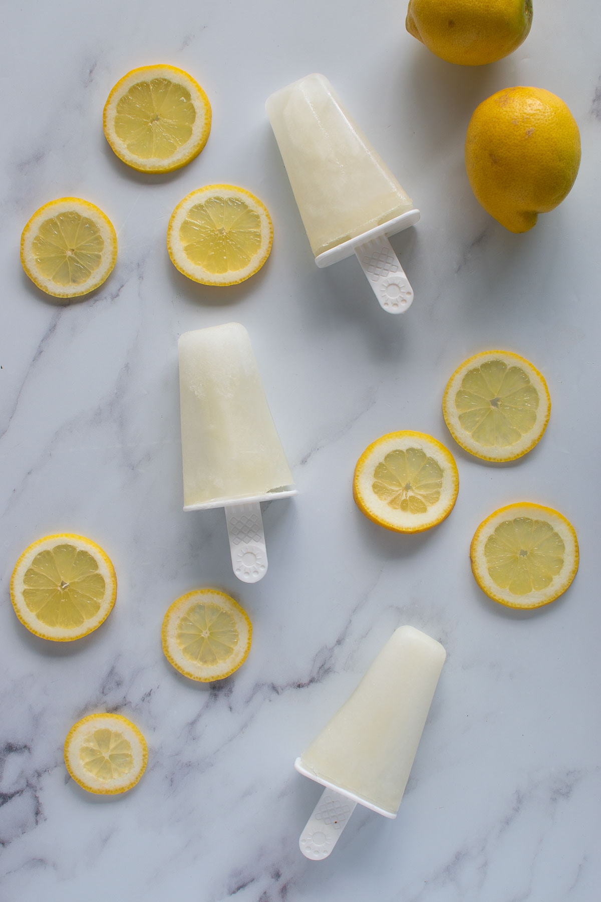 Thee lemonade popsicles on a table.