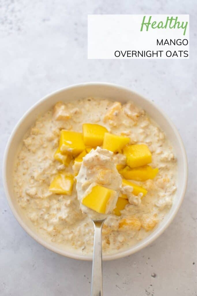 A bowl of mango overnight oats, with a spoon.