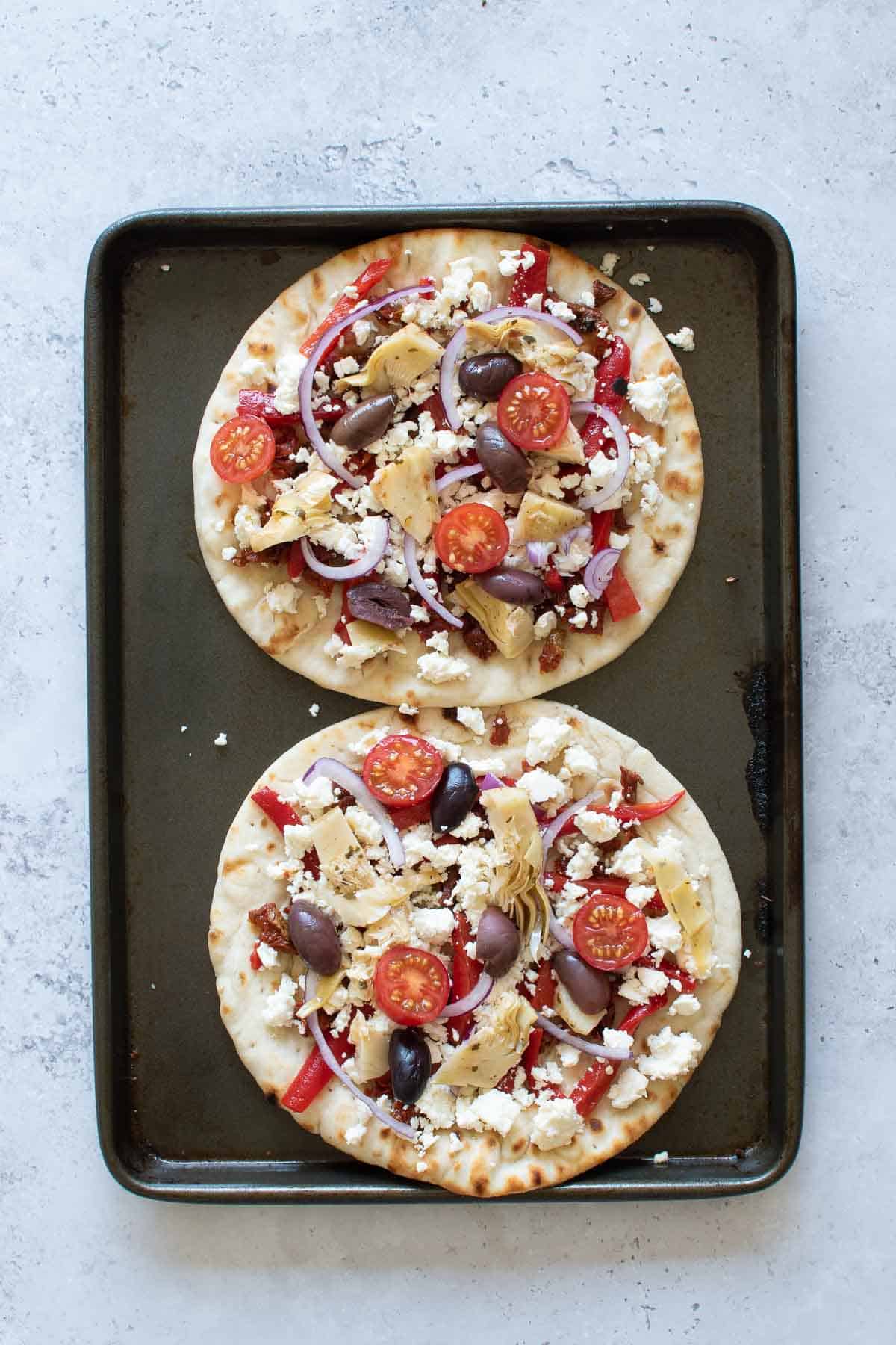 Uncooked flatbreads on a baking sheet.